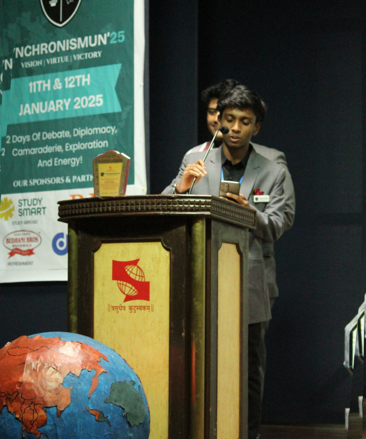 Akchhat speaking at a lectern during a conference